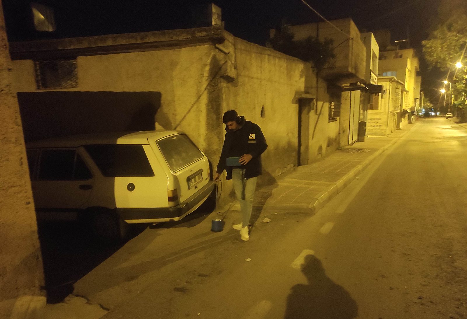 Gece bir sokakta yer mikrofonuyla akustik dinleme yapan saha personeli
